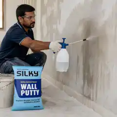Professional worker dampening a prepared wall before applying Silky Wall Putty.