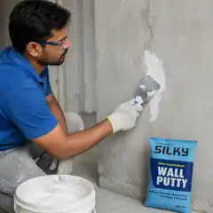 Professional worker filling fine wall cracks with Silky Wall Putty and a putty blade.