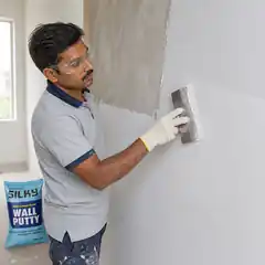 Professional worker smoothing the second coat of Silky Wall Putty with a finishing trowel.