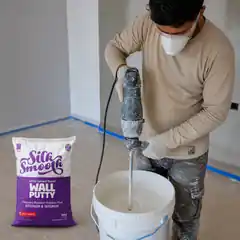 Professional worker mixing Silky Wall Putty using a low-speed paddle mixer.
