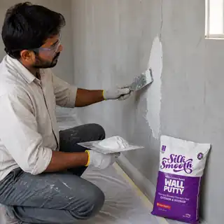 Professional worker filling fine wall cracks with Silky Wall Putty and a putty blade.