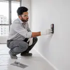 Worker checking that the Acrylic Wall Putty coat is dry before the next coat.